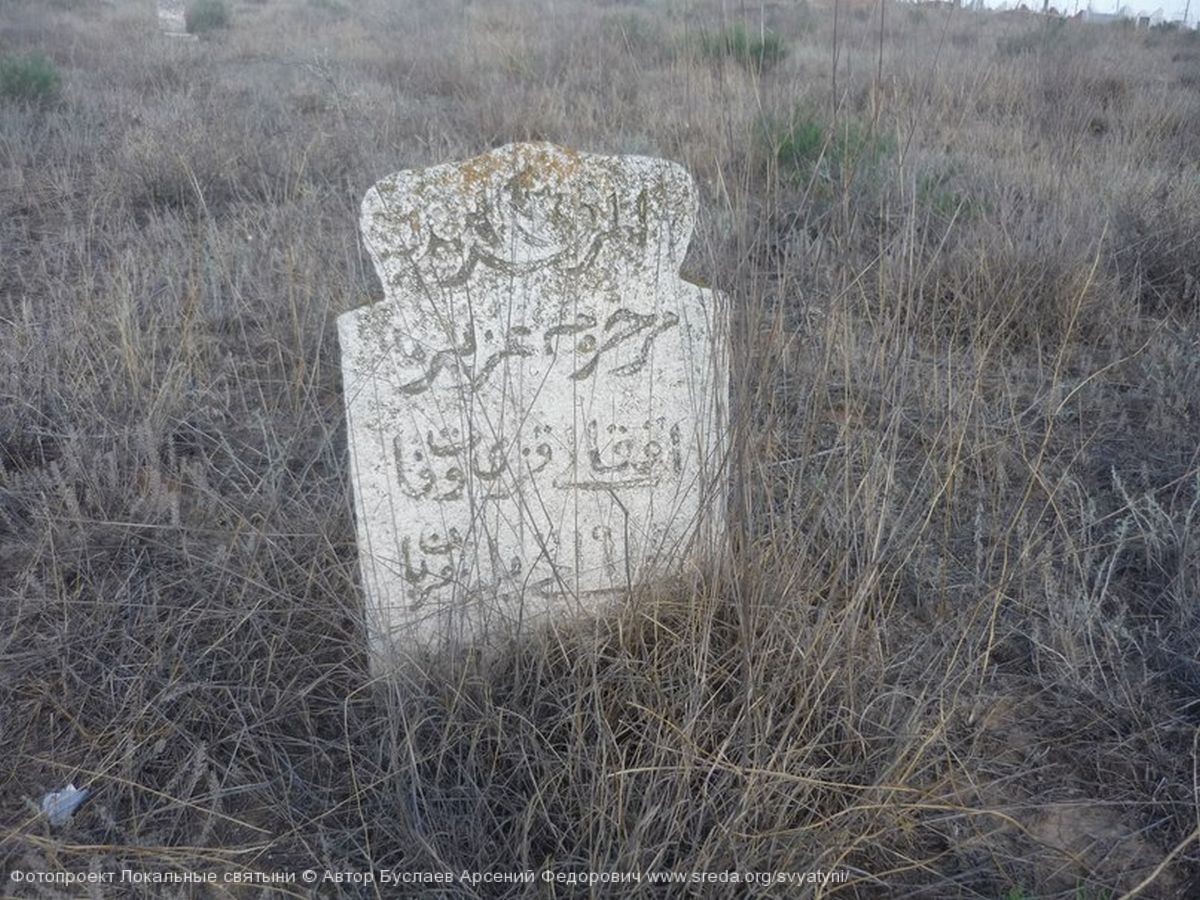 Древний могильный камень с сохранившимися надписями.